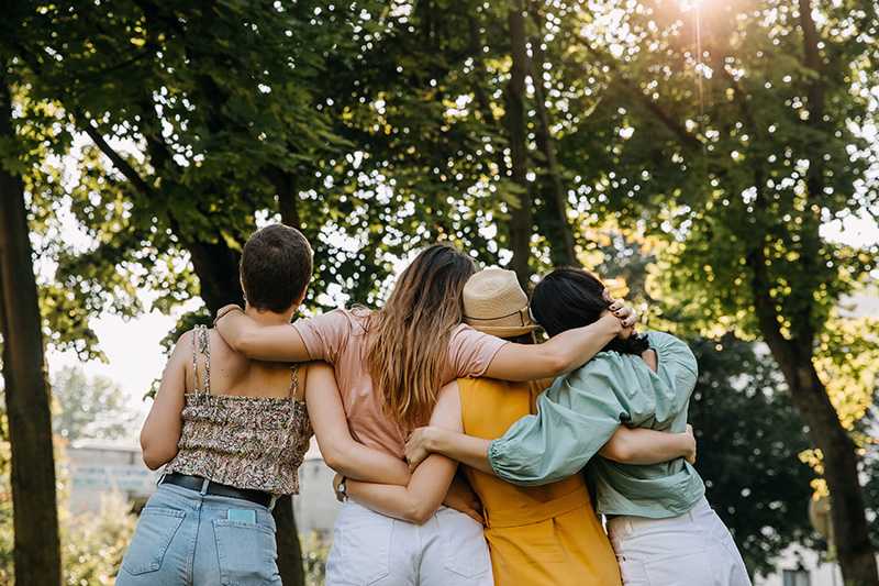 A group of friends stands outside together.