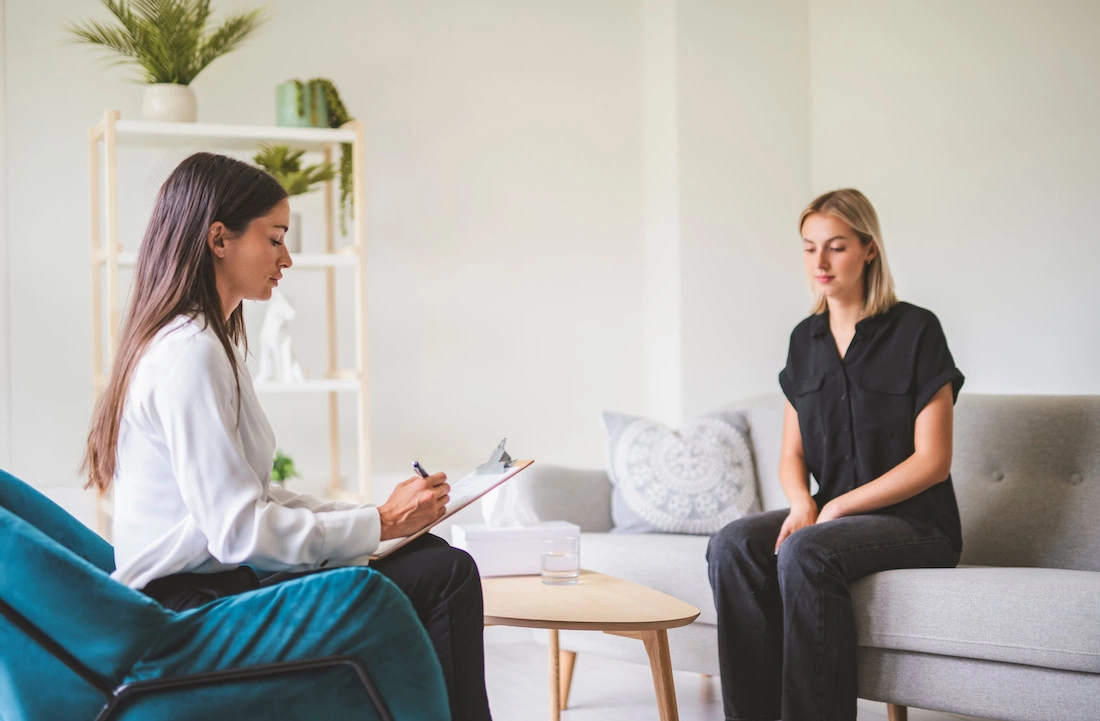 A person works with a therapist to identify therapy goals for PTSD.